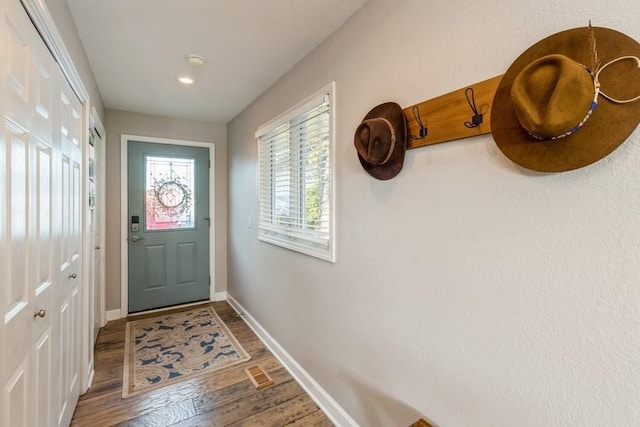 doorway to outside with visible vents, baseboards, and wood finished floors