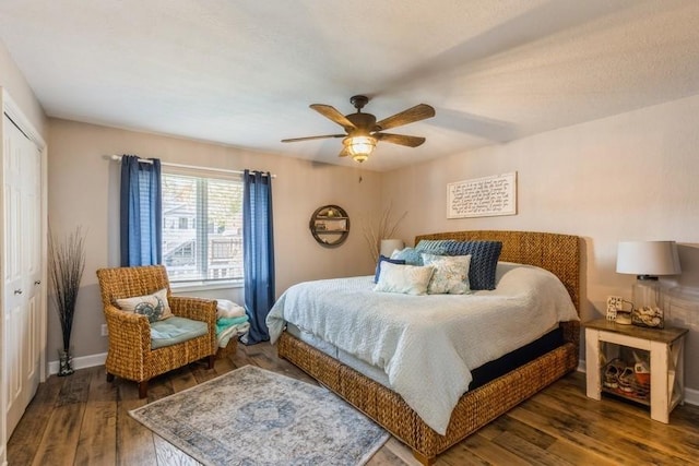 bedroom with a closet, baseboards, a ceiling fan, and wood finished floors