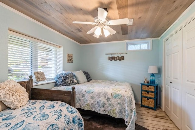 bedroom featuring crown molding, wood finished floors, a closet, and wooden ceiling