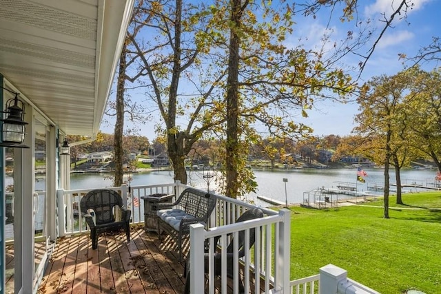 wooden deck with a yard and a water view