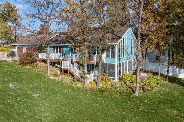 view of outdoor structure featuring stairway, fence, and a sunroom