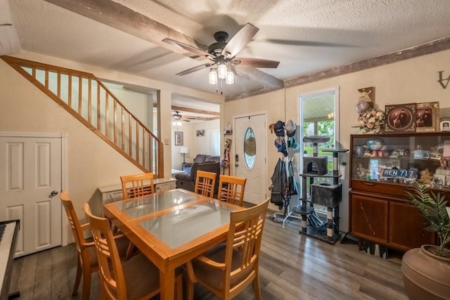 dining area featuring stairway, a textured ceiling, dark wood-type flooring, and a ceiling fan