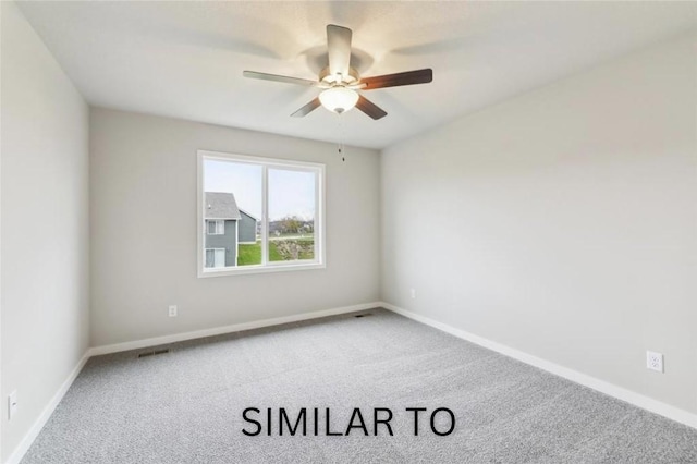 carpeted spare room featuring visible vents, ceiling fan, and baseboards