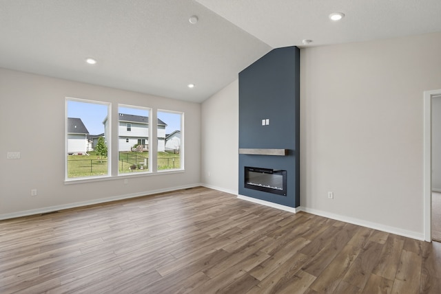 1811 Tuscany Dr SE, Altoona, IA 50009 - unfurnished living room with wood finished floors, lofted ceiling, a large fireplace, and recessed lighting