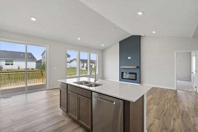 1811 Tuscany Dr SE, Altoona, IA 50009 - kitchen featuring stainless steel dishwasher, light wood finished floors, a large fireplace, lofted ceiling, and a center island with sink