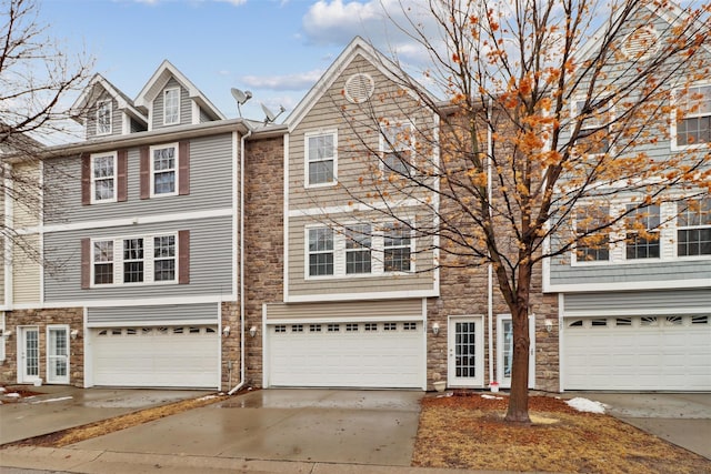 view of front of home with stone siding, driveway, and a garage