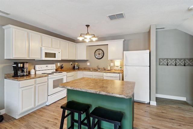 kitchen featuring visible vents, white appliances, and white cabinetry