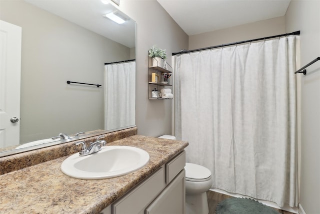 full bath featuring a shower with shower curtain, toilet, wood finished floors, and vanity