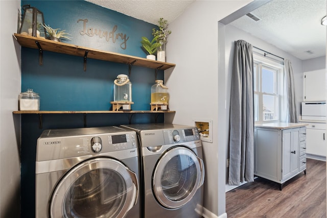 clothes washing area featuring wood finished floors, visible vents, washing machine and clothes dryer, laundry area, and a textured ceiling