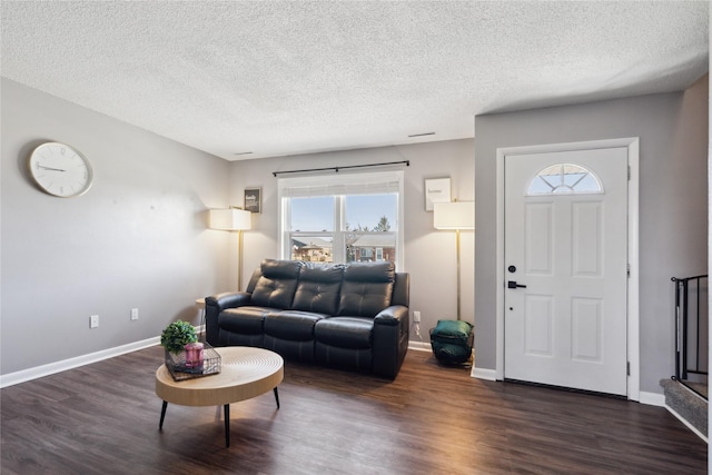 living area featuring a textured ceiling, stairs, baseboards, and dark wood-style flooring