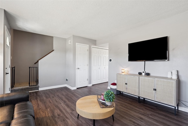 living room with wood finished floors, baseboards, and a textured ceiling