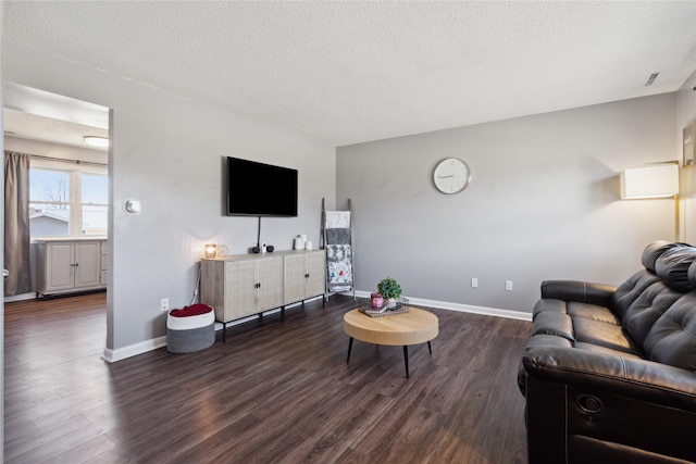 living area featuring baseboards, a textured ceiling, and wood finished floors