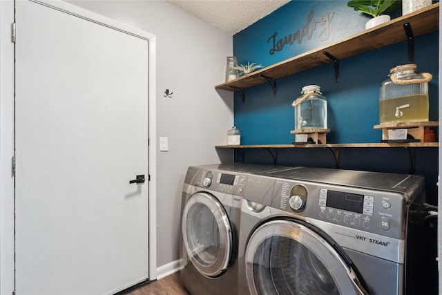 laundry area featuring baseboards, washing machine and dryer, laundry area, wood finished floors, and a textured ceiling