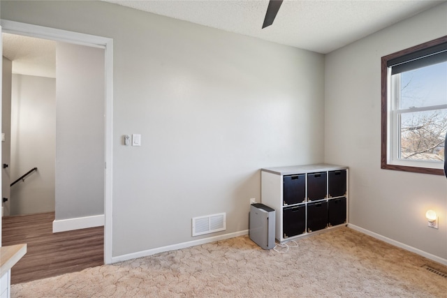 unfurnished bedroom featuring visible vents, a textured ceiling, and baseboards