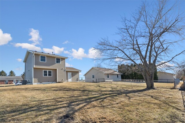 back of house with a lawn and fence