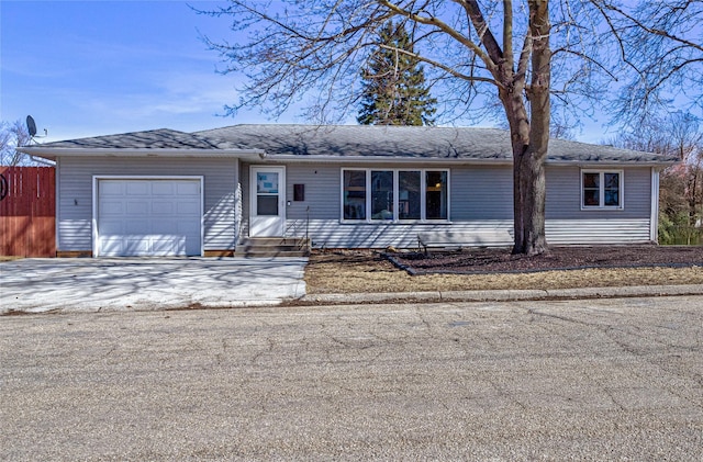 ranch-style home featuring an attached garage, driveway, and entry steps