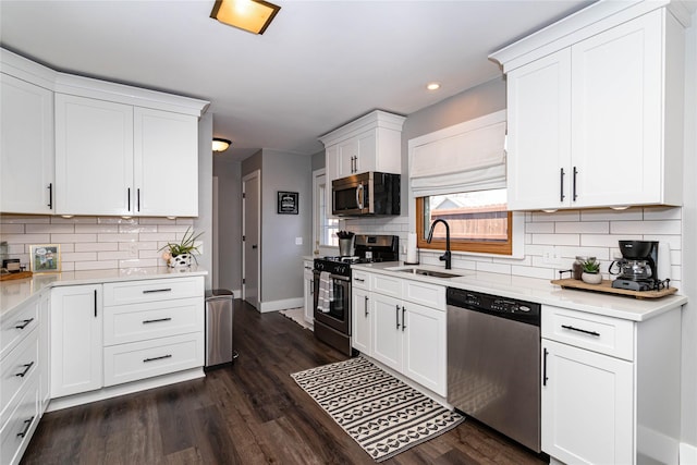 kitchen featuring dark wood finished floors, stainless steel appliances, light countertops, and a sink