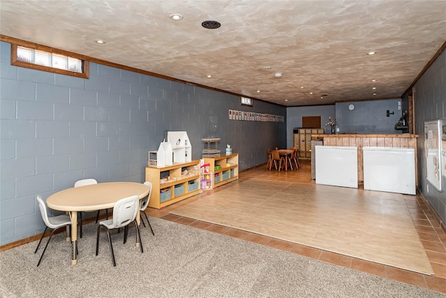 playroom with recessed lighting, concrete block wall, and tile patterned floors