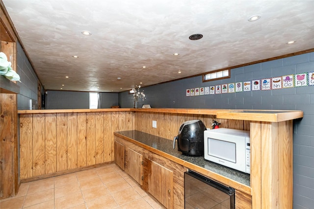 kitchen with beverage cooler, recessed lighting, concrete block wall, light tile patterned floors, and white microwave