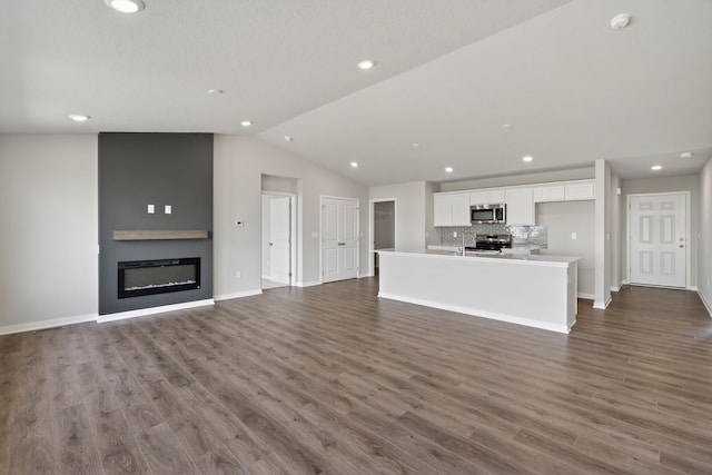 1803 Tuscany Dr SE, Altoona, IA 50009 - unfurnished living room with lofted ceiling, a fireplace, dark wood-style floors, and recessed lighting