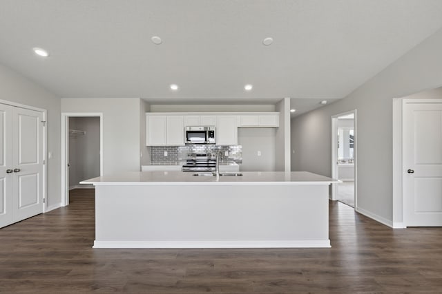 1803 Tuscany Dr SE, Altoona, IA 50009 - kitchen featuring appliances with stainless steel finishes, an island with sink, white cabinetry, dark wood-type flooring, and recessed lighting