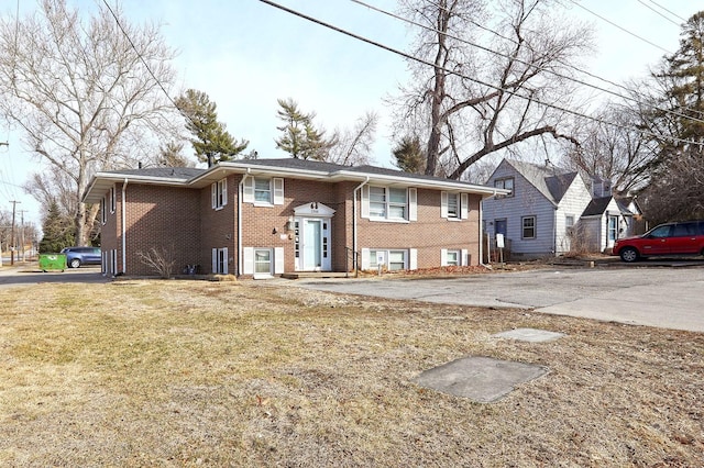 bi-level home with a front yard and brick siding