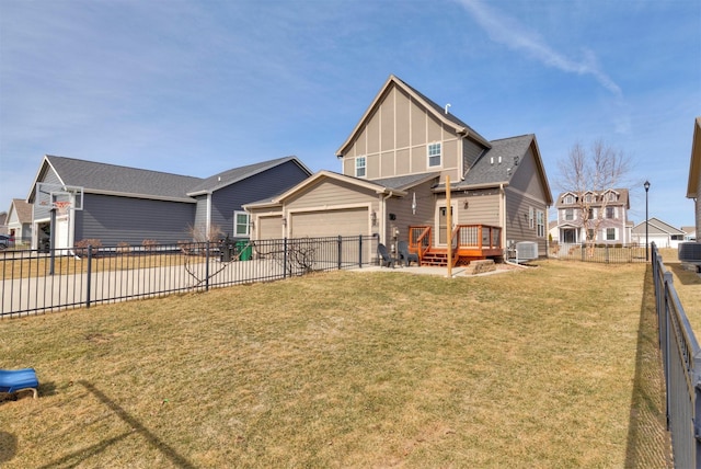 view of front of home with central air condition unit, an attached garage, fence private yard, and a front lawn