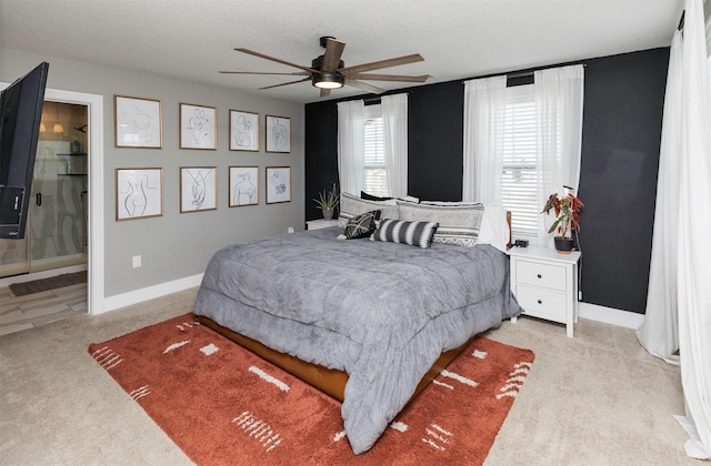 bedroom with light carpet, a textured ceiling, and baseboards