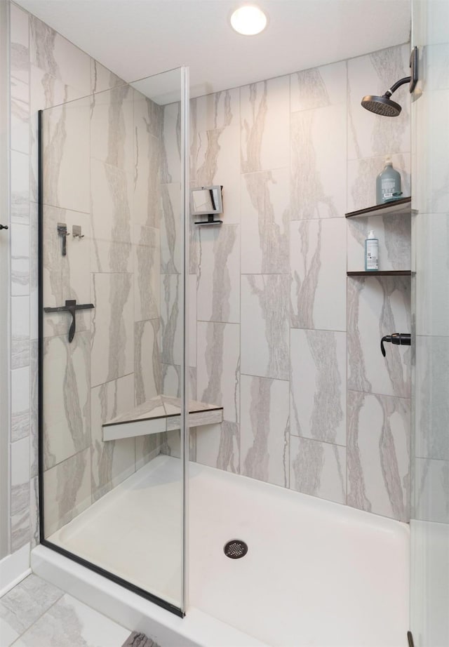 full bath featuring a shower stall and marble finish floor