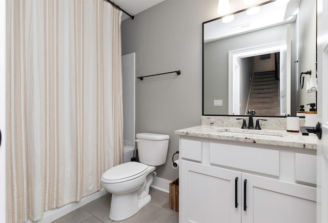 bathroom with baseboards, toilet, shower / bath combo with shower curtain, tile patterned floors, and vanity