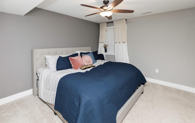 carpeted bedroom featuring a ceiling fan, baseboards, and visible vents