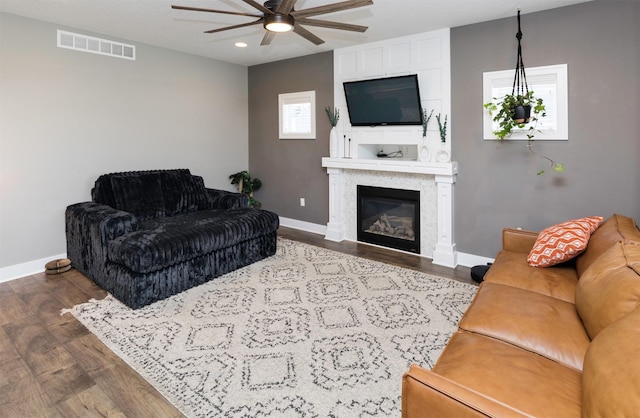 living room with visible vents, baseboards, and wood finished floors