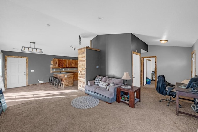 carpeted living room featuring a sink and vaulted ceiling