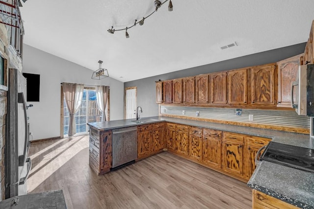 kitchen featuring light wood finished floors, visible vents, vaulted ceiling, appliances with stainless steel finishes, and a sink