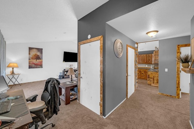 home office featuring vaulted ceiling, light colored carpet, and a textured ceiling