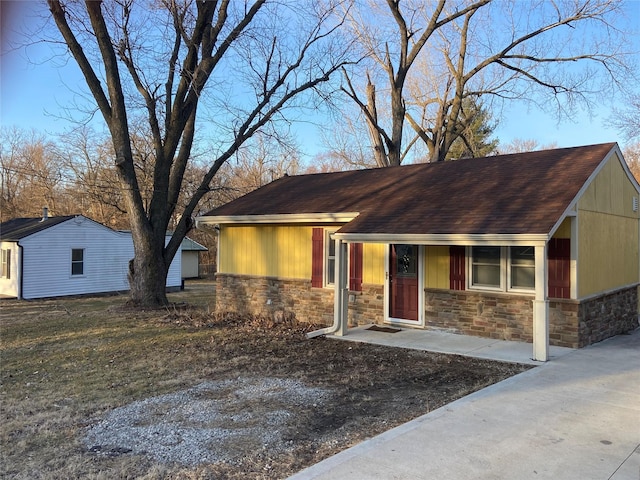 view of front of home featuring stone siding and roof with shingles