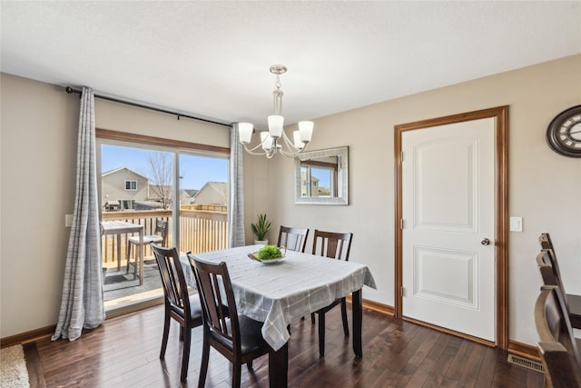 dining room featuring dark wood-style floors, baseboards, and a chandelier