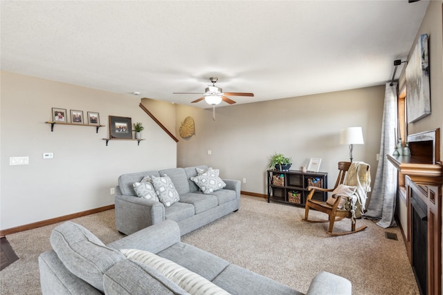 living room with baseboards, light carpet, visible vents, and ceiling fan