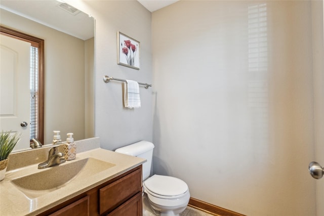 half bathroom with visible vents, toilet, and vanity