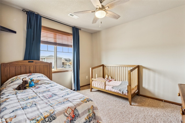 bedroom with a ceiling fan, visible vents, baseboards, and carpet floors