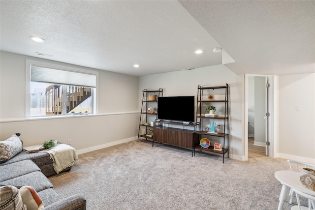 living area with recessed lighting, a textured ceiling, baseboards, and carpet