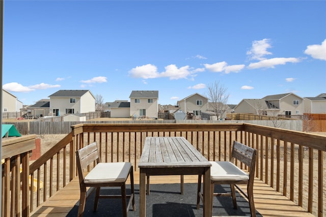 deck featuring a residential view, outdoor dining area, and a fenced backyard