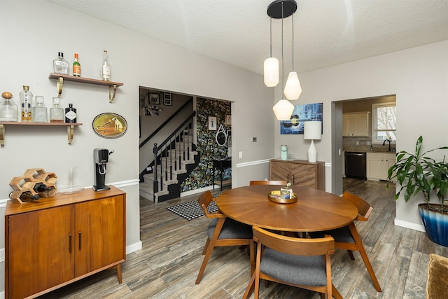 dining space featuring stairway, wood finished floors, and a textured ceiling