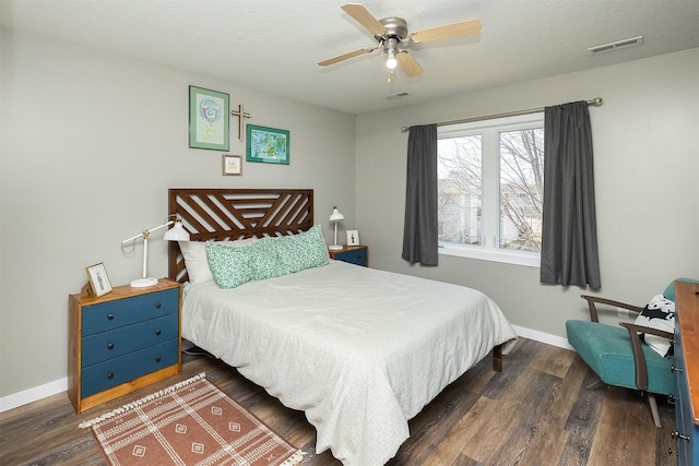 bedroom with dark wood-style floors, visible vents, and baseboards