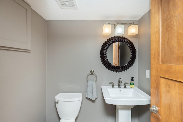 half bath with toilet and visible vents