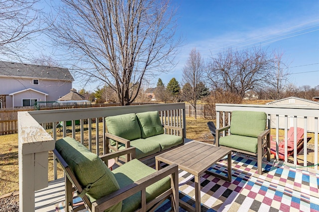 wooden deck featuring an outdoor living space and a fenced backyard