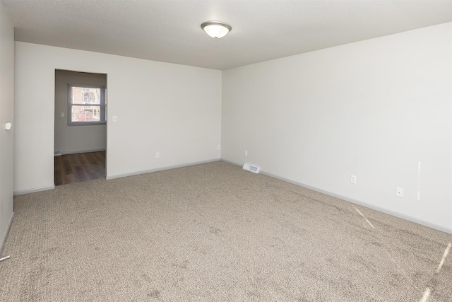 unfurnished room featuring visible vents, baseboards, and carpet floors