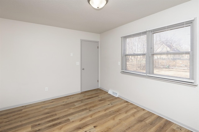 unfurnished room with visible vents, baseboards, and light wood finished floors