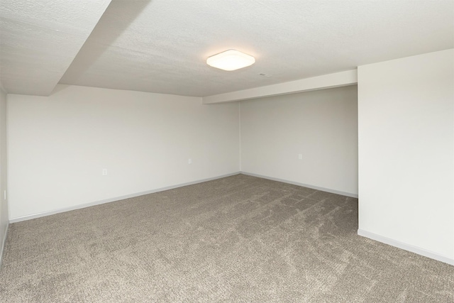 carpeted empty room featuring baseboards and a textured ceiling