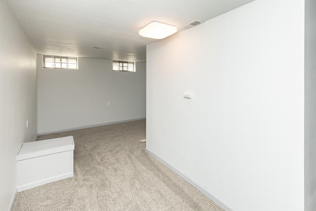 basement with visible vents, baseboards, and carpet